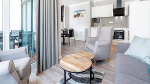 A modern apartment with a dining area, kitchen, and seating with a view. - 4 Star Holiday Home in Travemunde (Lübeck)