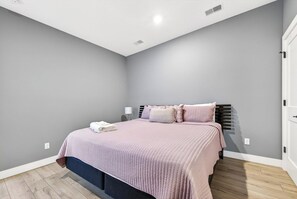 A bedroom with a bed, bedside tables, and a wardrobe. - The Lofts - Unit 2 (Fennville)