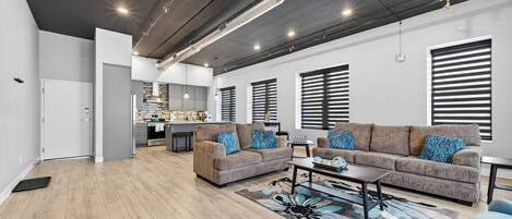 A modern living room with a sofa set, coffee table, and patterned rug.