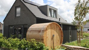 A modern building with a large wooden barrel, a sloped roof, and a small window. - Stylish Coastal Home With Garden (Sint Maarten)