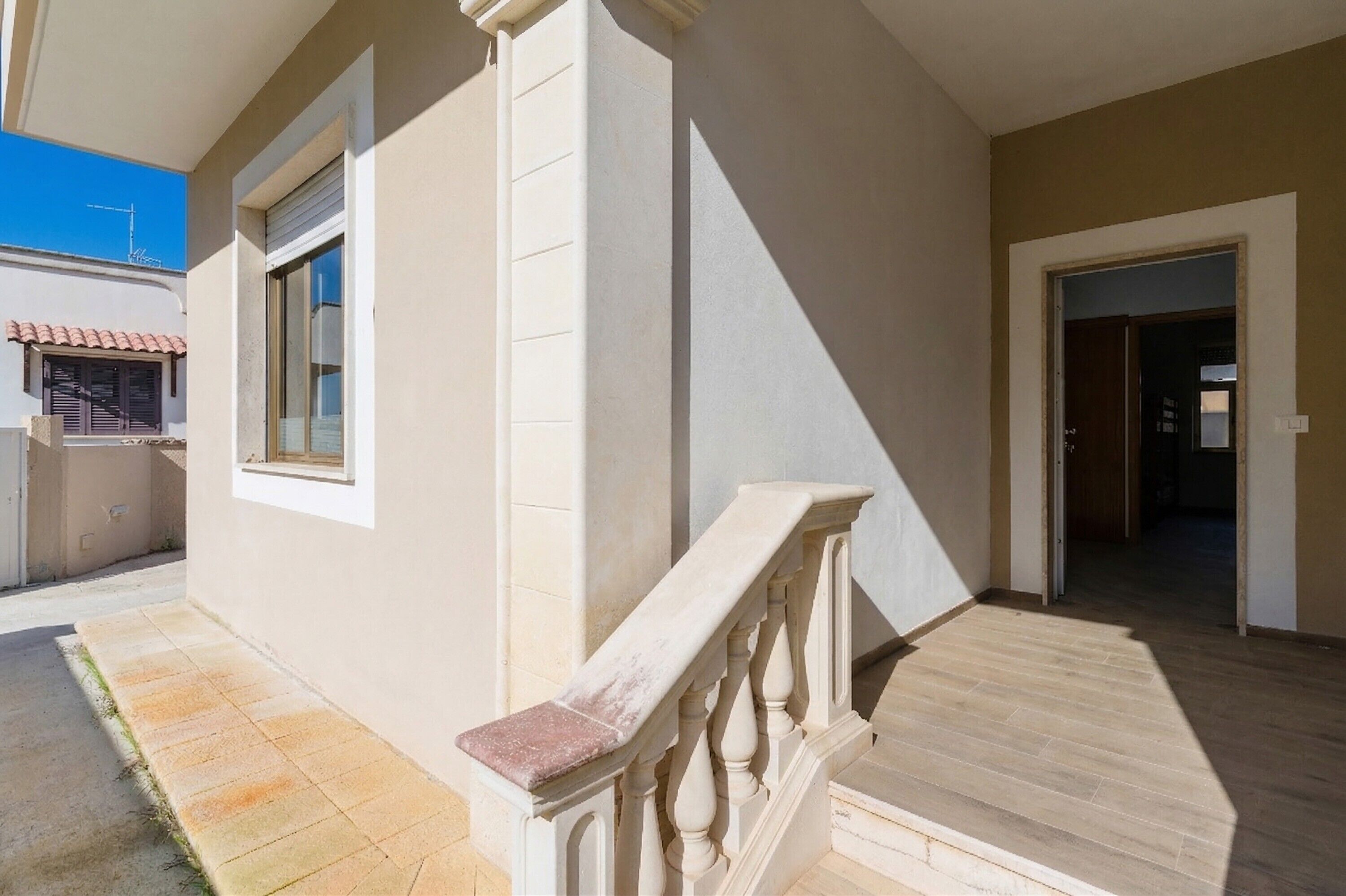 Un bâtiment doté d’un balcon, d’une fenêtre et d’une porte.