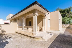 Ein Gebäude mit überdachter Veranda, Säulen und einem kleinen Eingang.