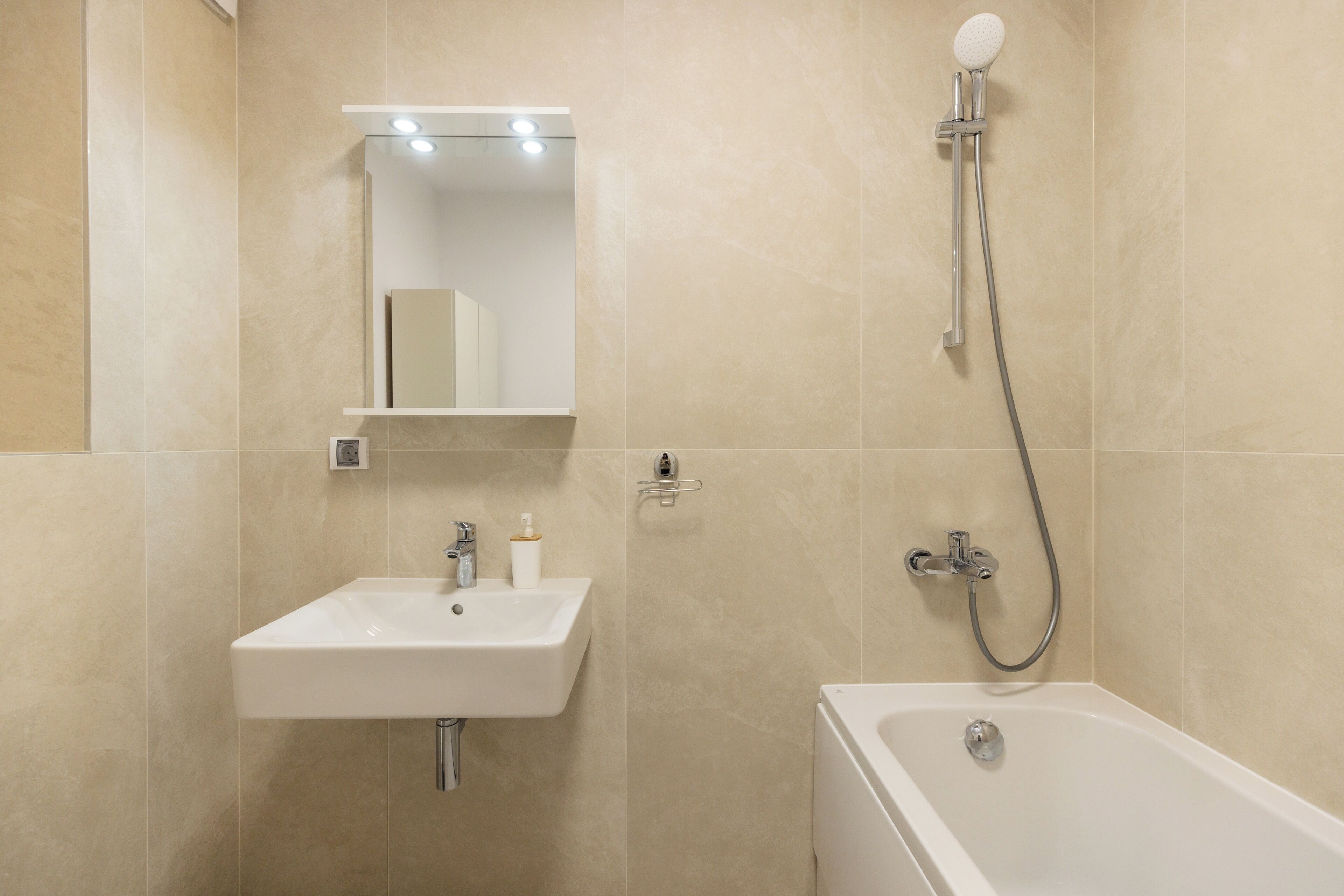 Ein Badezimmer mit Waschbecken, Spiegel und Dusche.