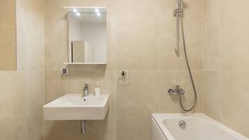 Ein Badezimmer mit Waschbecken, Spiegel und Dusche.