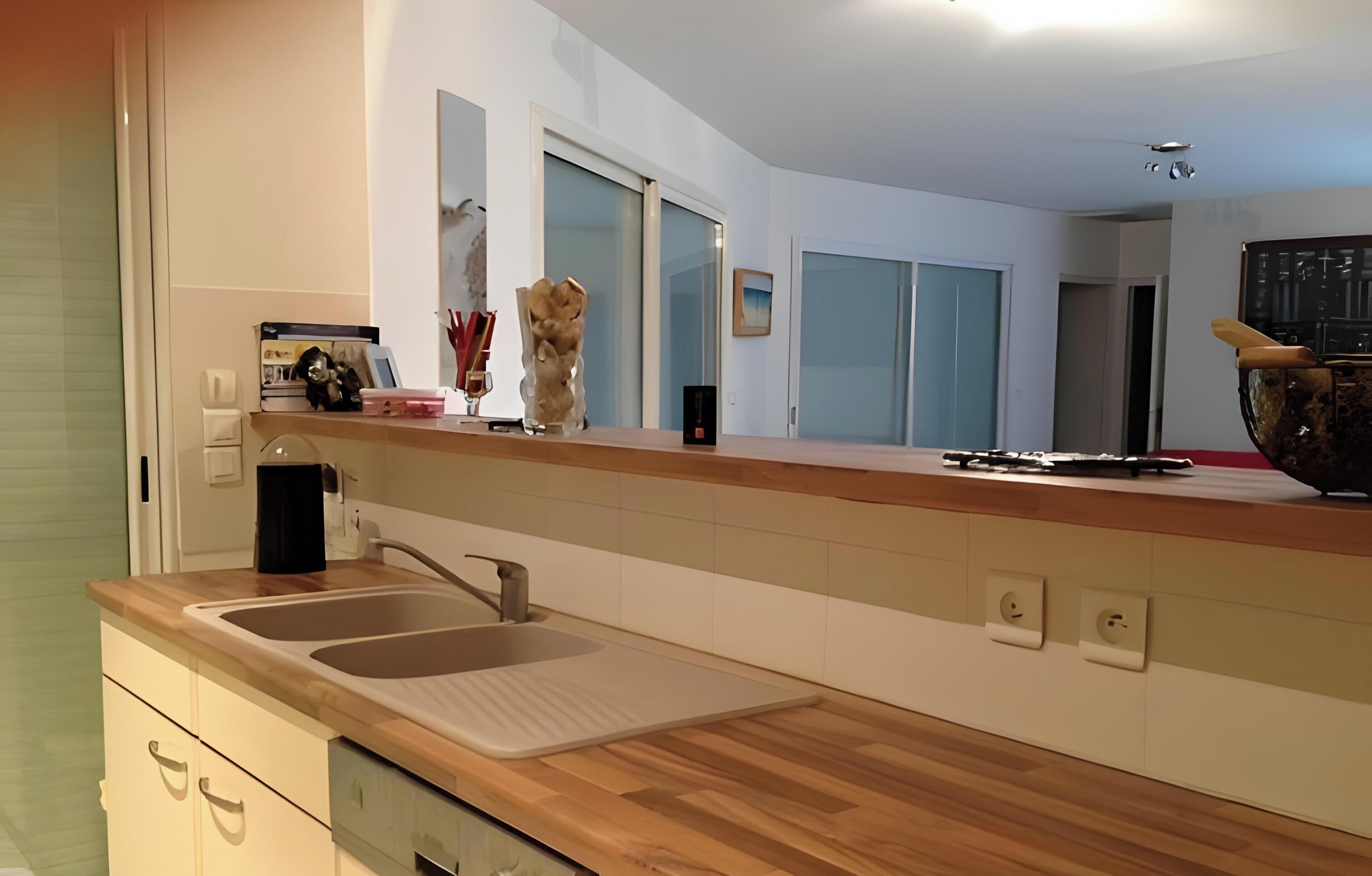 Eine moderne Küche mit Holzauskładung, Spüle und integriertem Backofen.