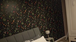 A bed with a plaid bedspread, a grey upholstered headboard, and white pillows. - Beautiful 2-room apartment in the heart of Taucha (Taucha)