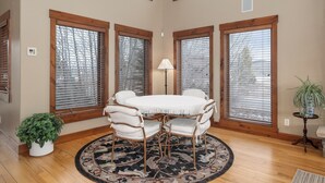 A dining area with a round table, chairs, and a rug.