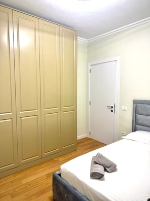 A bedroom with a bed, a wardrobe, and a door.
