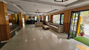Eine Hotlellobby mit einer Rezeption, einer Couch und einem Couchtisch.
