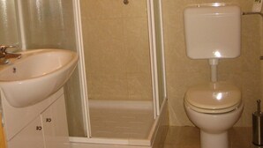 Une salle de bain avec une douche, un lavabo et des toilettes.