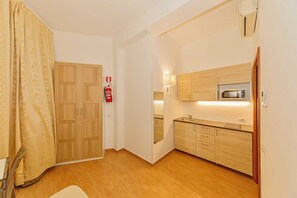 Eine kleine Küche mit Holzausstattung, einer Mikrowelle und einer eingebauten Spüle.