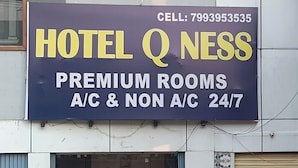 A hotel sign with 'HOTEL Q NESS' and 'PREMIUM ROOMS A/C & NON A/C 24/7' indicating room types and amenities. - HOTEL Q NESS  (Hyderabad)