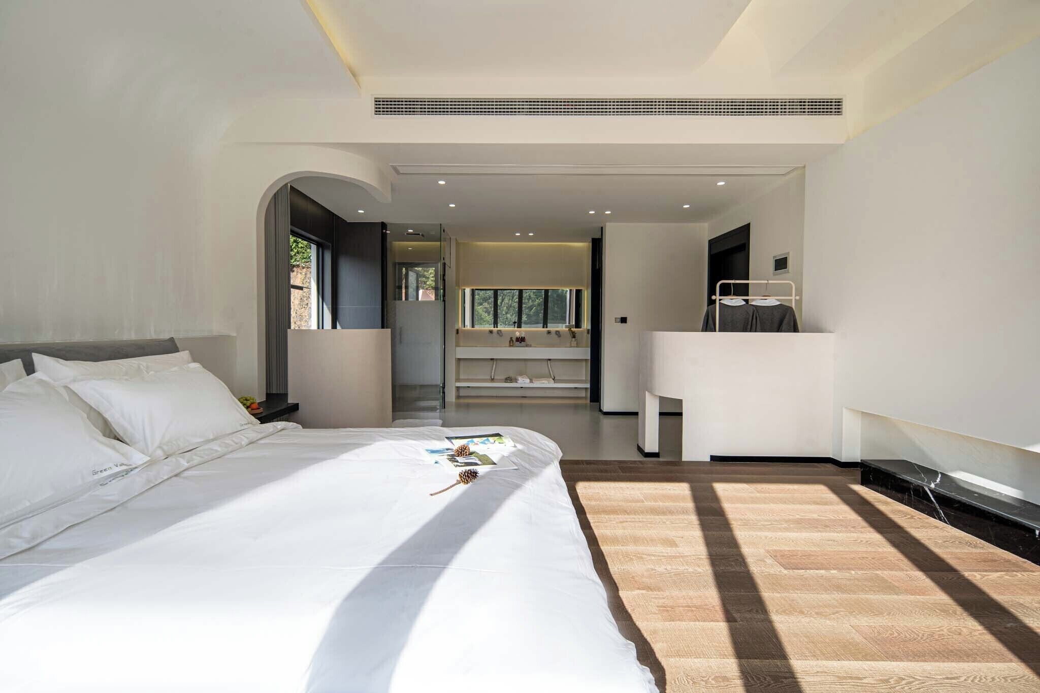Habitación de hotel moderna con una cama grande, un escritorio y vistas al exterior.