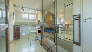 Cozinha moderna com área de jantar, escada e quarto com vista.