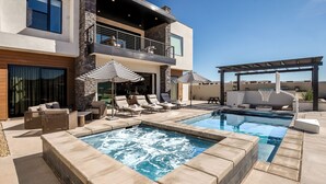 Uma casa moderna com piscina, área de estar ao ar livre e uma pérgula.