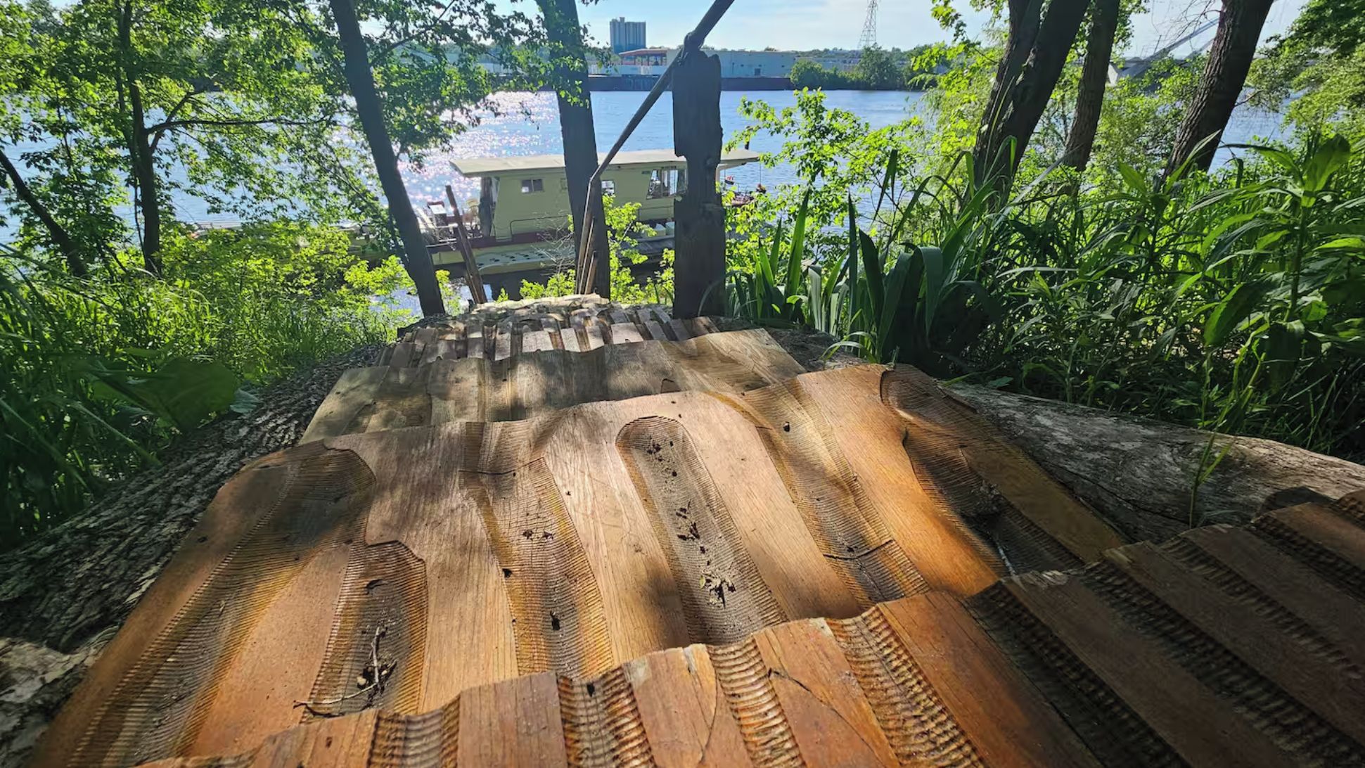 A wooden staircase leading to a dock with a view of a body of water and buildings in the background.