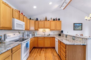 A kitchen with wooden cabinets, a microwave, a stove, and a sink. - Crestone at Lakepoint Ridge Townhome: Walk to Bike Path & Trails, Lake Dillon (Frisco)