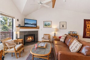 A living room with a fireplace, a television, and a balcony. - Crestone at Lakepoint Ridge Townhome: Walk to Bike Path & Trails, Lake Dillon (Frisco)