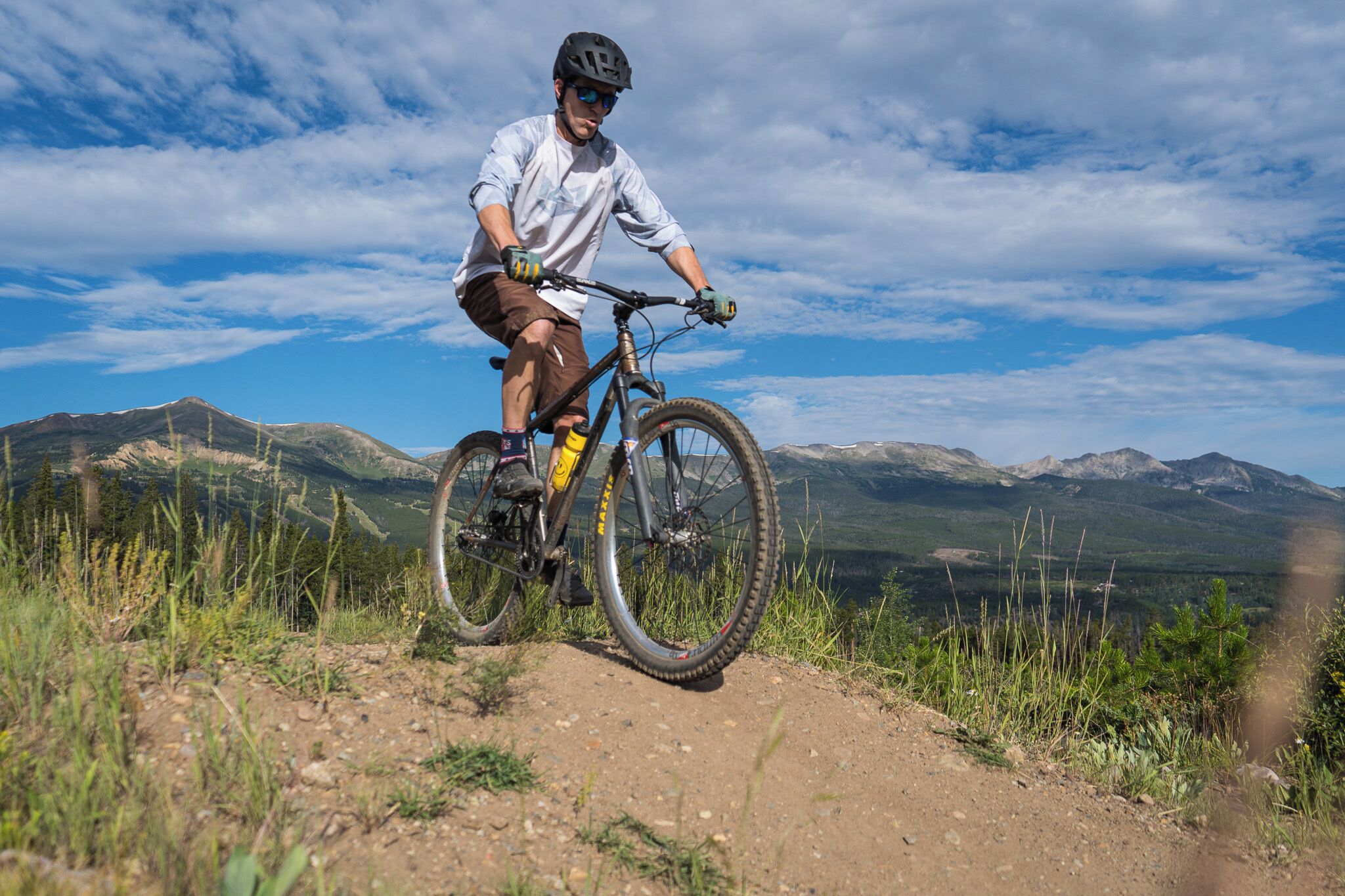 Ein Mountainbiker auf einem Trail mit einer Bergkulisse im Hintergrund.