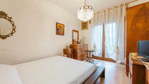 A bedroom with a bed, dresser, vanity, and a television. - Ca' Fedon - Mountain View Terrace (Domegge di Cadore)