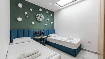 Habitación de hotel con dos camas, un tragaluz y un muro decorativo.
