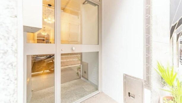 A room with a sliding glass door leading to a balcony, a small window, and a door with a handle. - AP12 NICE APARTMENT IN DOWNTOWN (Milano)