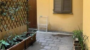 A courtyard with a wooden fence, a metal gate, and potted plants. - AP12 NICE APARTMENT IN DOWNTOWN (Milano)