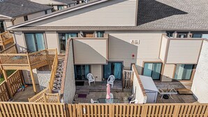 Ein Wohngebäude mit überdachter Terrasse, Sitzgelegenheiten im Freien und einer Holzterrasse.