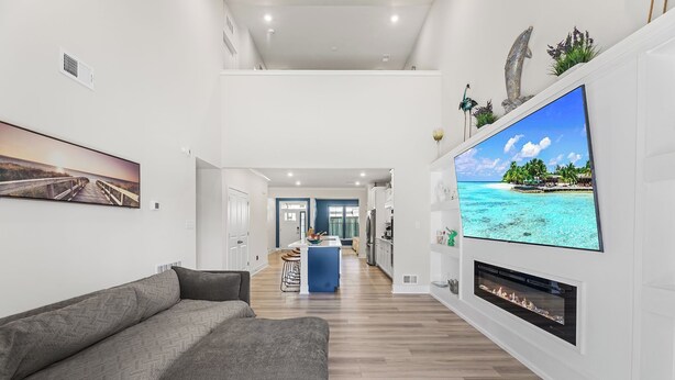 Ein modernes Wohnzimmer mit großem Flachbildfernseher, Kamin und einer Couch.