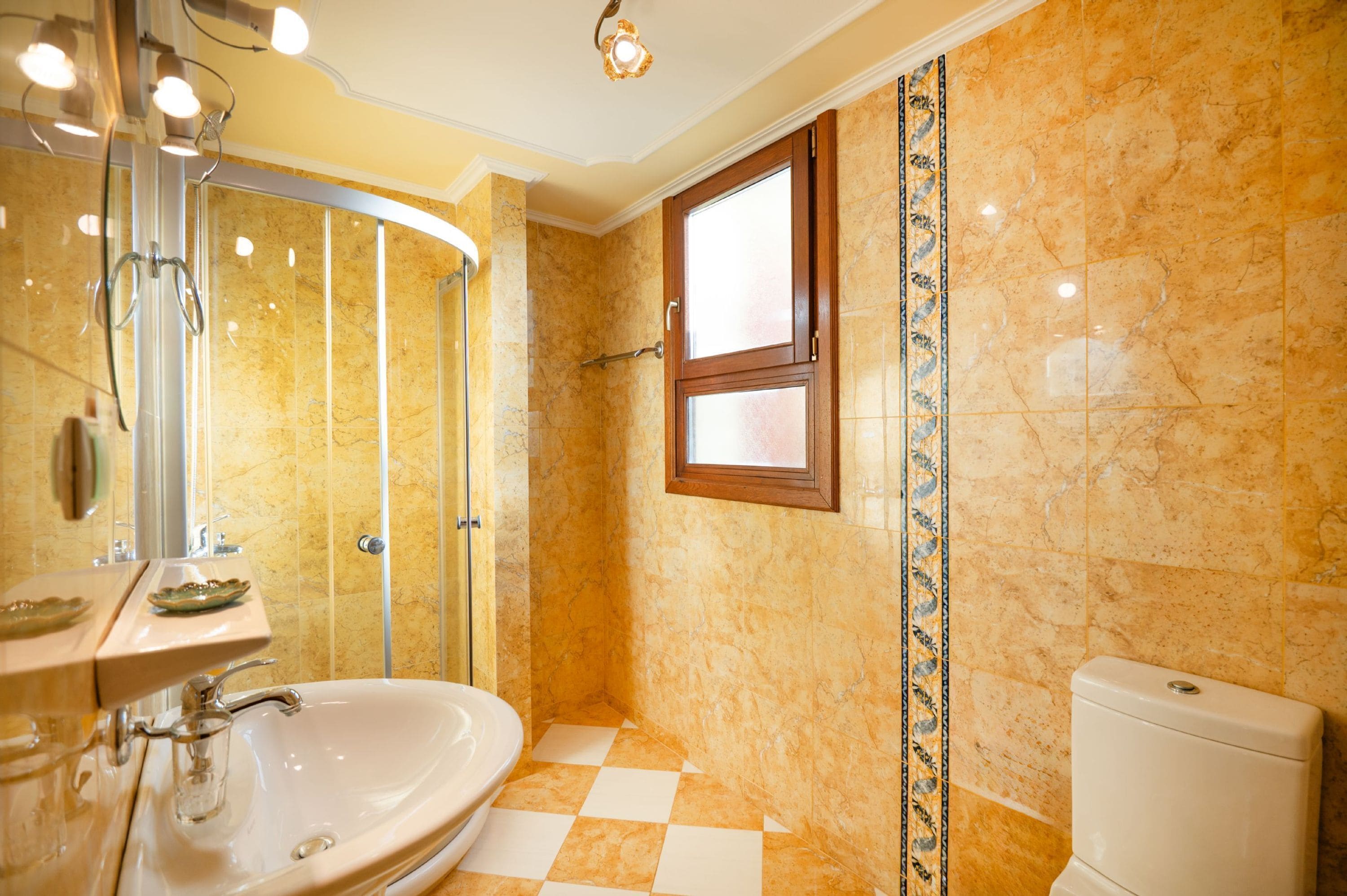 A bathroom with a sink, mirror, shower, and toilet.