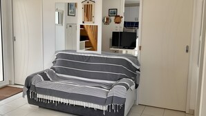 Een slaapkamer met een bed, een kledingkast, een spiegel en een televisietoestel.