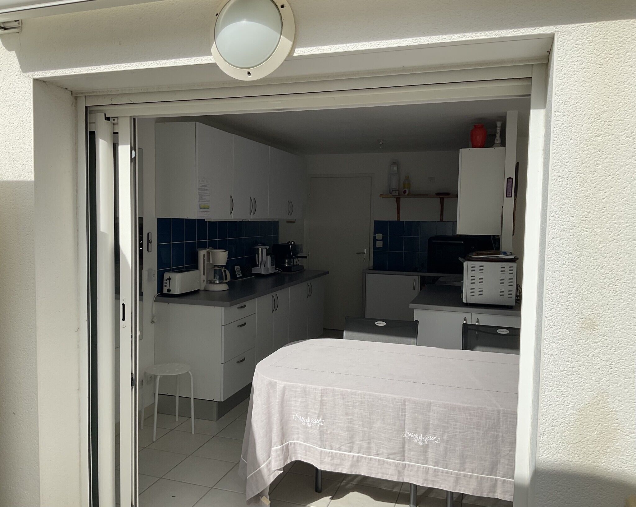 A compact kitchen with white cabinets, a coffee maker, and a microwave.