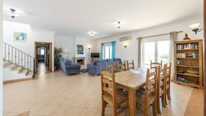 A spacious living area with a dining table, sofas, and a staircase. - Villa Nina With 4 Bedrooms and 4 Bathrooms (Olhao)