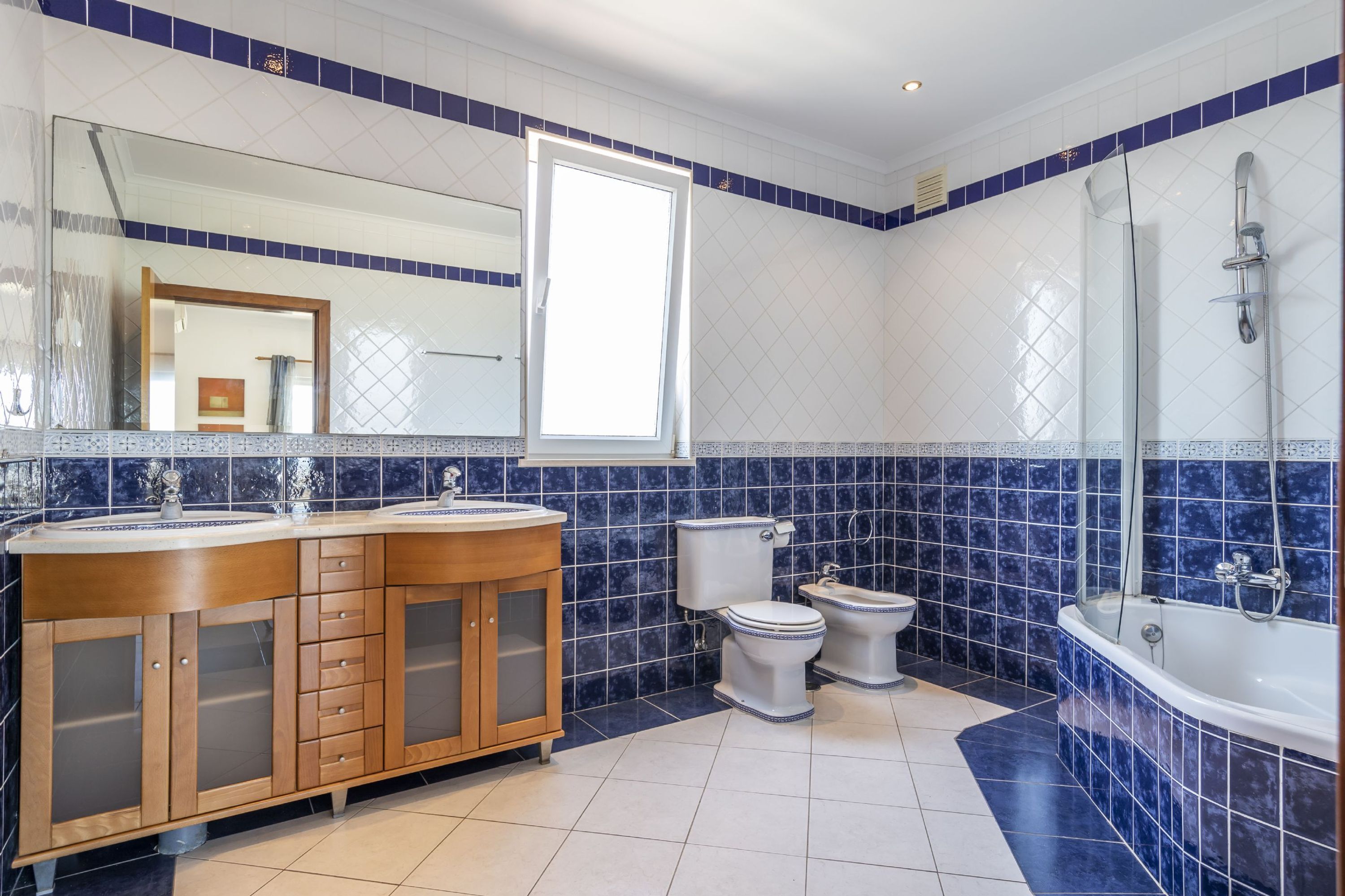 Un bagno con doppio lavabo, un water, un bidet e una vasca da bagno.