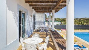 A covered outdoor area with a pool, white furniture, and a view of the landscape. - Villa Nina With 4 Bedrooms and 4 Bathrooms (Olhao)