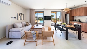 Ein modernes Wohnzimmer mit einer Couch, einem Couchtisch und einem Essbereich mit Stühlen.