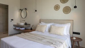 Ein modernes Schlafzimmer mit einem Bett, einem Nachttisch und einem wandmontierten Schminktisch mit Waschbecken.