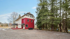 A red building with a gravel driveway and a fenced area. - Ramoni Apartments - Enzzauber - Bad Wildbad (Bad Wildbad)