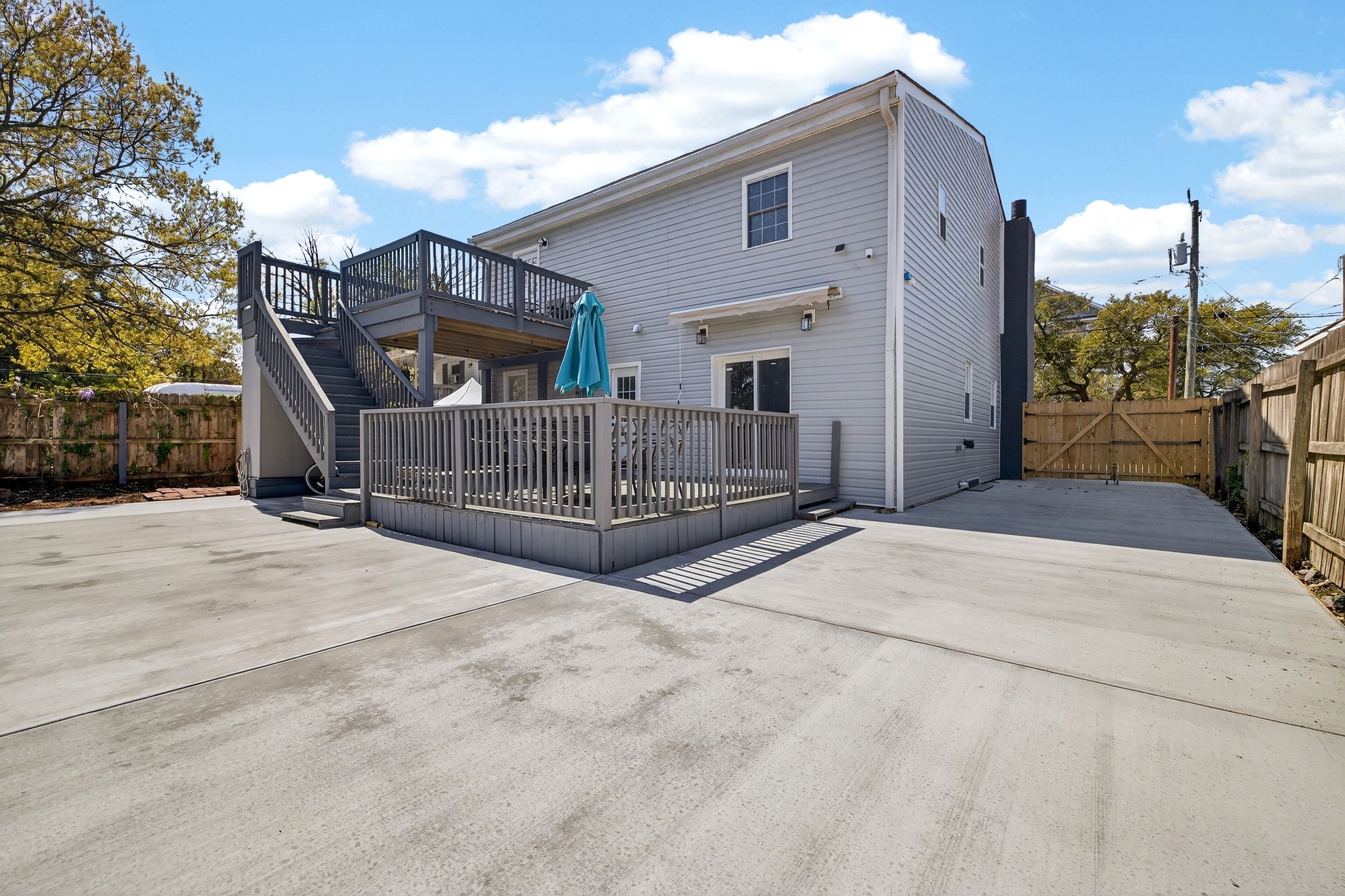A two-story house with a balcony, a staircase, and a fenced backyard.