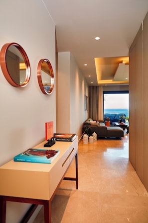 Een modern interieur met een bureau, twee spiegels aan de muur, een bank en uitzicht op de oceaan.
