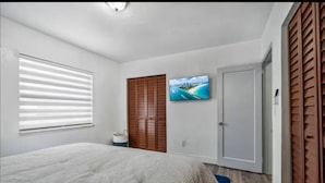 A bedroom with a bed, a TV, a wardrobe, and a window with blinds. - Cozy house in the heart Of Miami (Miami)