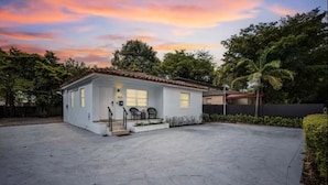 A single-story house with a front porch, a small garden, and a driveway. - Cozy house in the heart Of Miami (Miami)