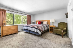 Ein Schlafzimmer mit Bett, Schminktisch, Stuhl und Fenster.