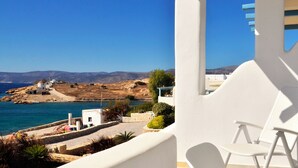 A coastal view with a white building, a chair, and a clear sky. - Villa Amorgos, Sohoro Koufonisia (Koufonisia)