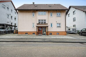 A multi-story building with a tiled roof, a central entrance with a door, and a small balcony. - Apartment "Kleeblatt" with Balcony and Wi-Fi (Bad Wildbad)