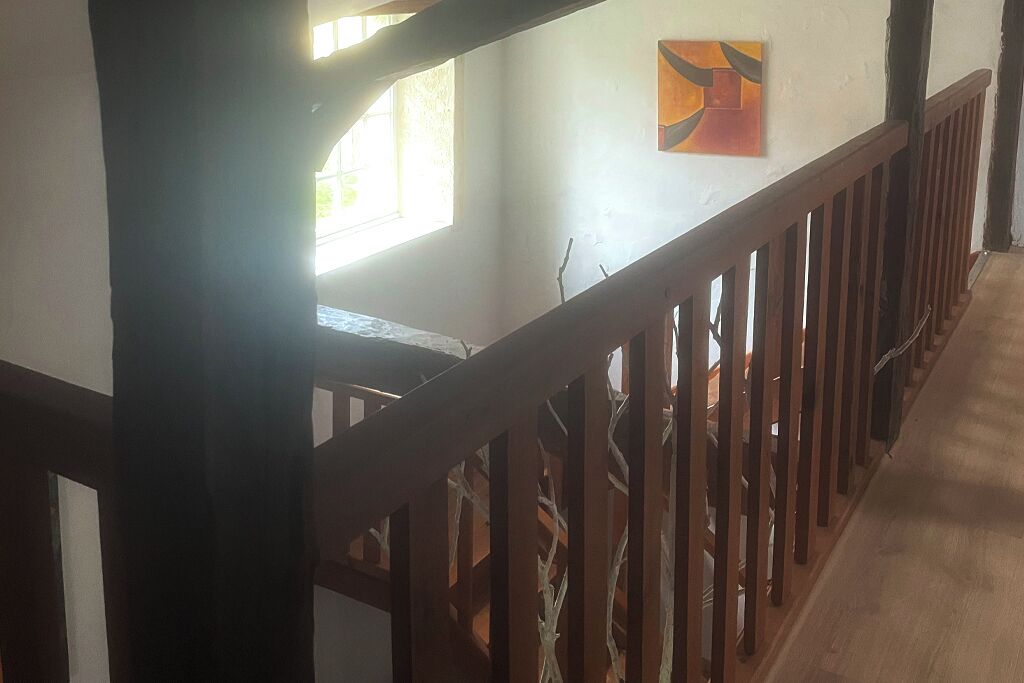 A staircase with wooden railings and a window with natural light.
