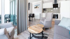 A modern living room with a sofa, a coffee table, and a view of a cityscape. - 4 Star Holiday Home in Travemunde (Lübeck)