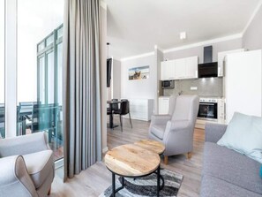 A modern living room with a sofa, a coffee table, and a view of a cityscape. - 4 Star Holiday Home in Travemunde (Lübeck)