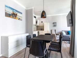 A modern living space with a dining area, kitchen, and seating area. - 4 Star Holiday Home in Travemunde (Lübeck)