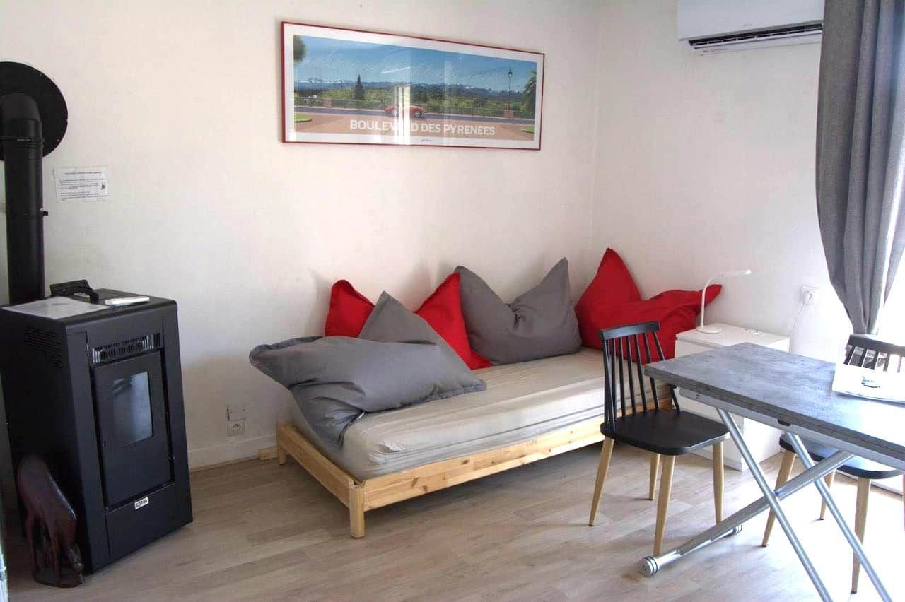 A compact room with a sofa, a small table, and a heater.